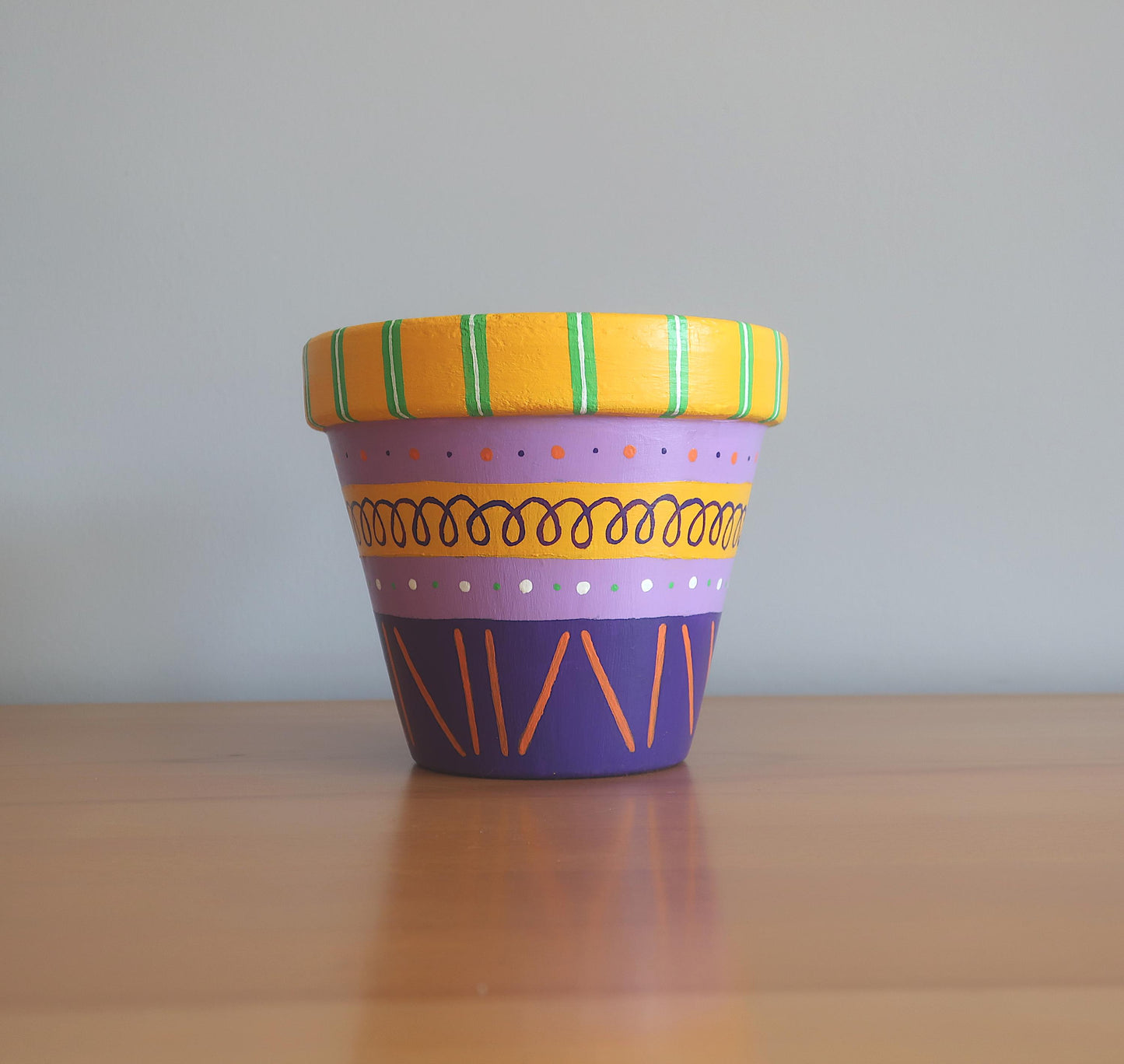 Handbemalter Blumentopf mit lila-gelbem Muster