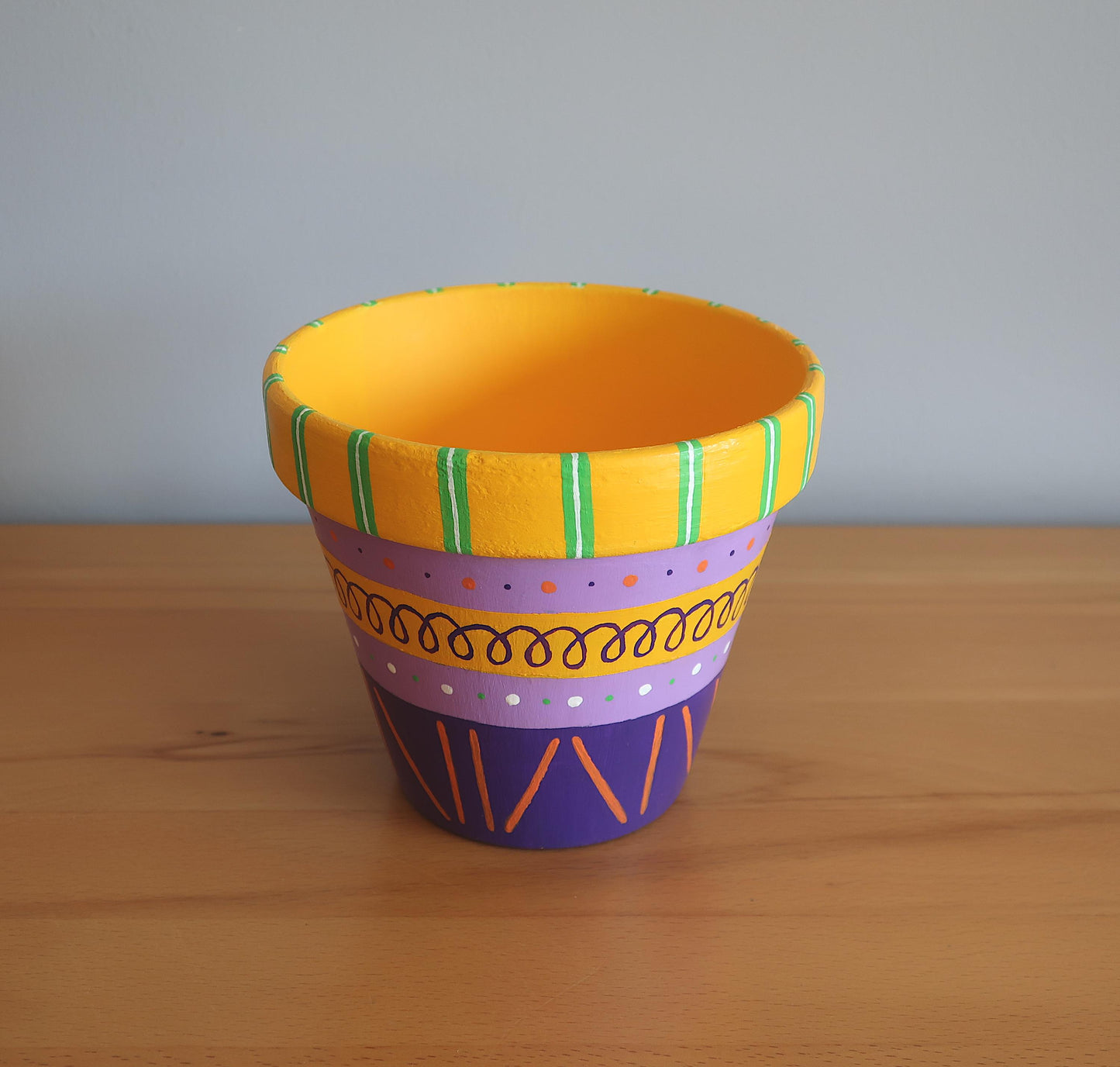 Handbemalter Blumentopf mit lila-gelbem Muster