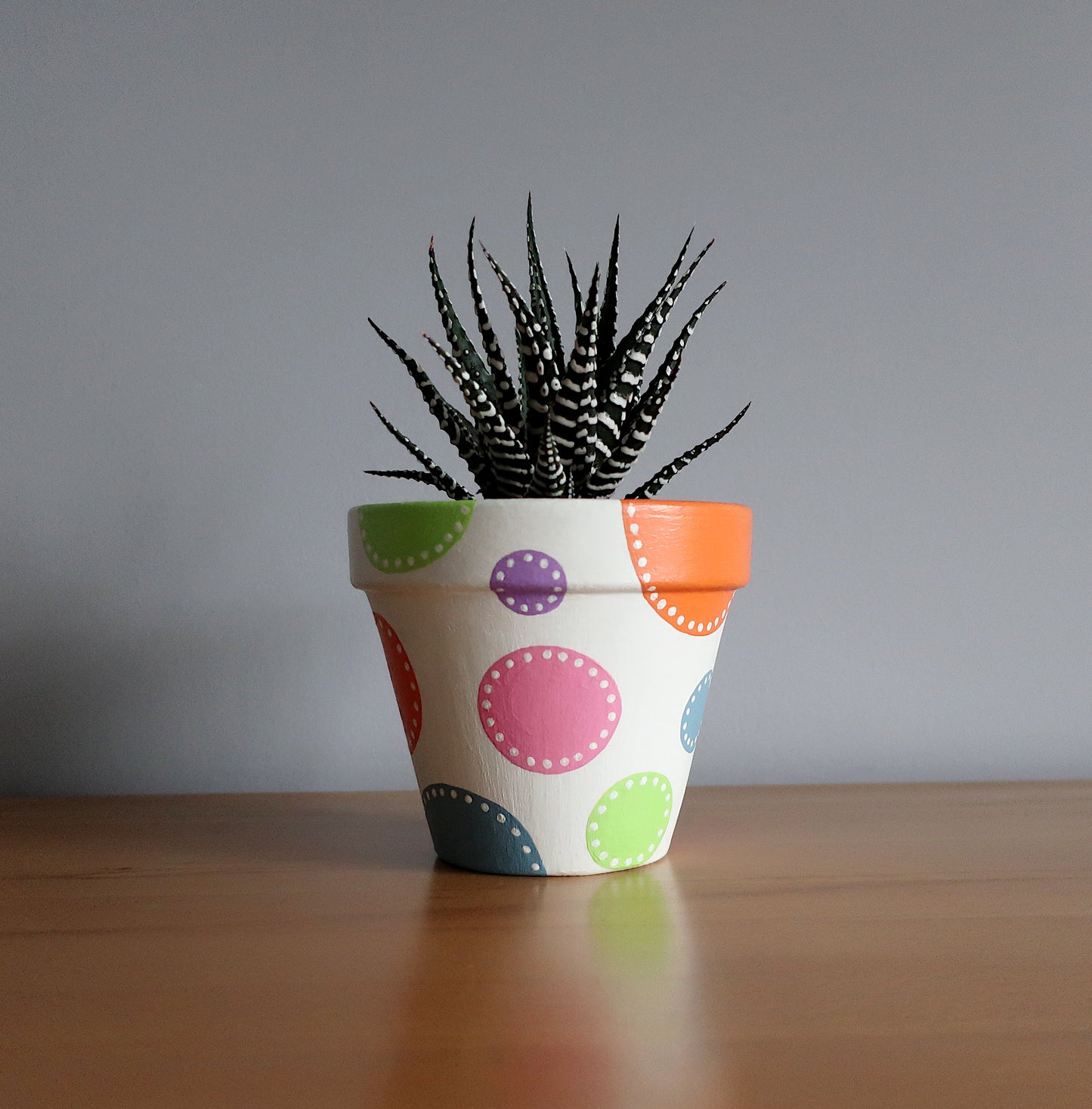 Handbemalter Blumentopf mit bunten Punkten