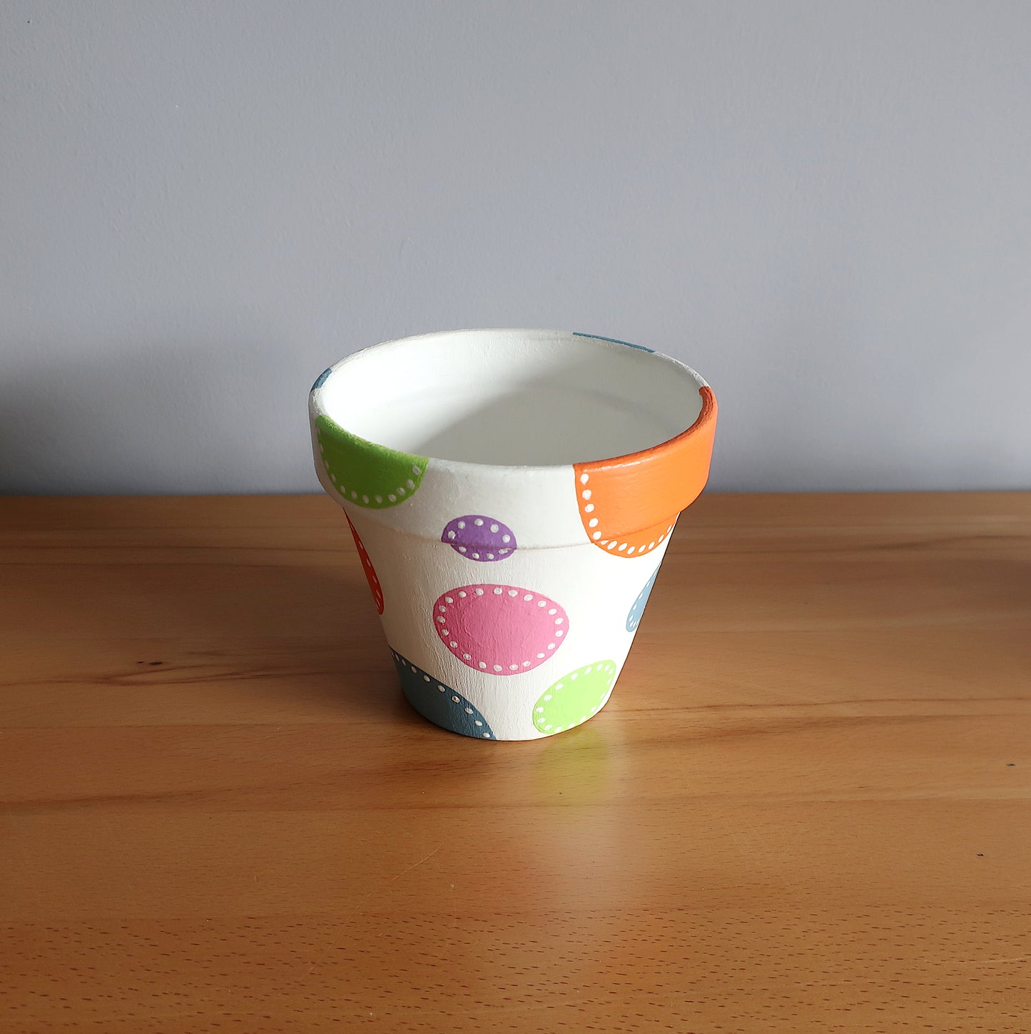 Handbemalter Blumentopf mit bunten Punkten